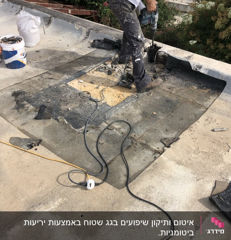 אדם קודח בגג לאיטום עם מקדחה חשמלית
